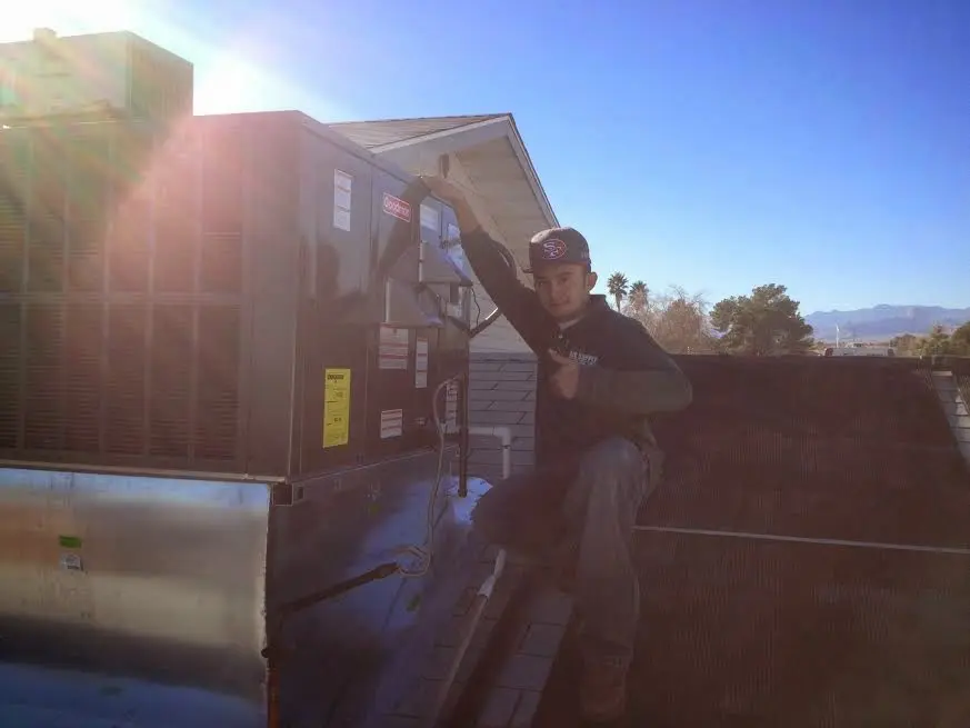 HVAC technician performing HVAC Inspection on a rooftop unit in Dale City